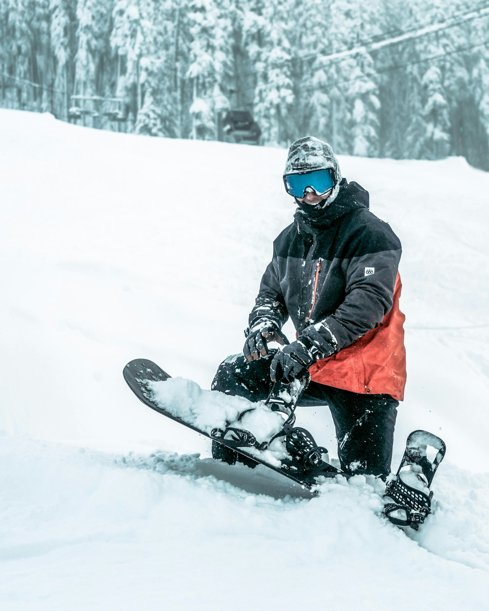 A snowboarder sitting in the snow with their board